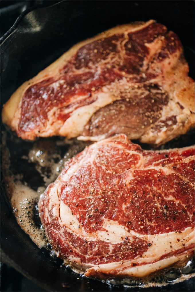 Shields Valley Ranchers rib and T-bone steaks start to heat up in a cast iron pan on the stove