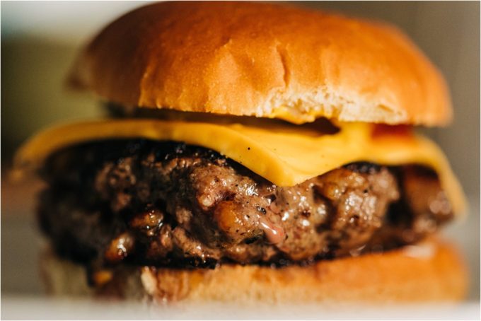 A Shields Valley Ranchers burger topped with cheese and placed between a bun is ready to eat.