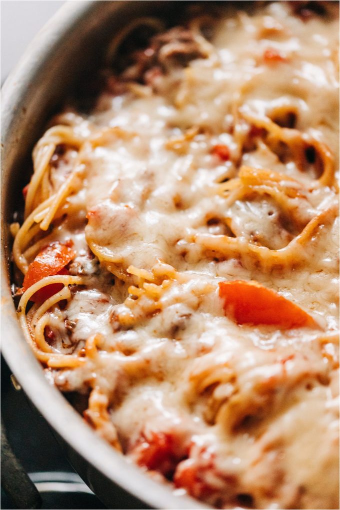 A pan of cooked spaghetti and Shields Valley Ranchers ground beef incorporated into spaghetti sauce is topped with melted parmesan.